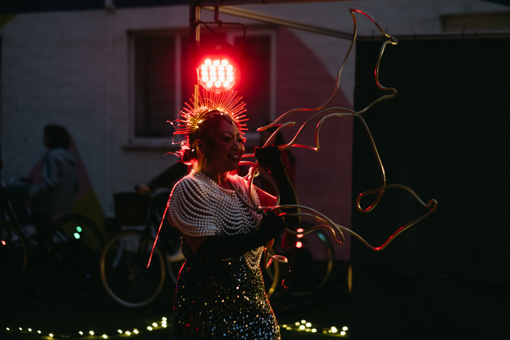Performer in a light-up headdress and sequinned outfit at a night-time event