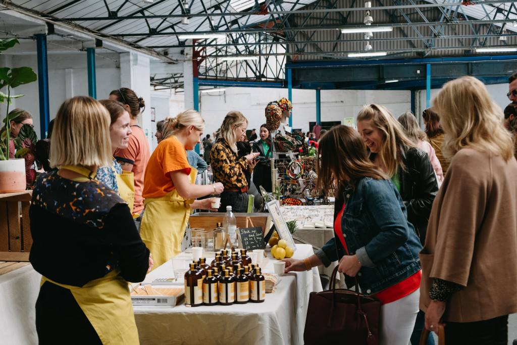 People browsing market stalls in a warehouse
